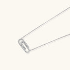 White gold plated necklace with dual-frame geometric pendant featuring crystal pavé border on pale background.